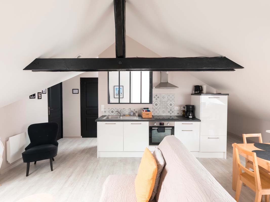 Two bedroom attic apartment. Kitchen open to living room, beams and black doors, canopy. Rental apartment Arras by the night